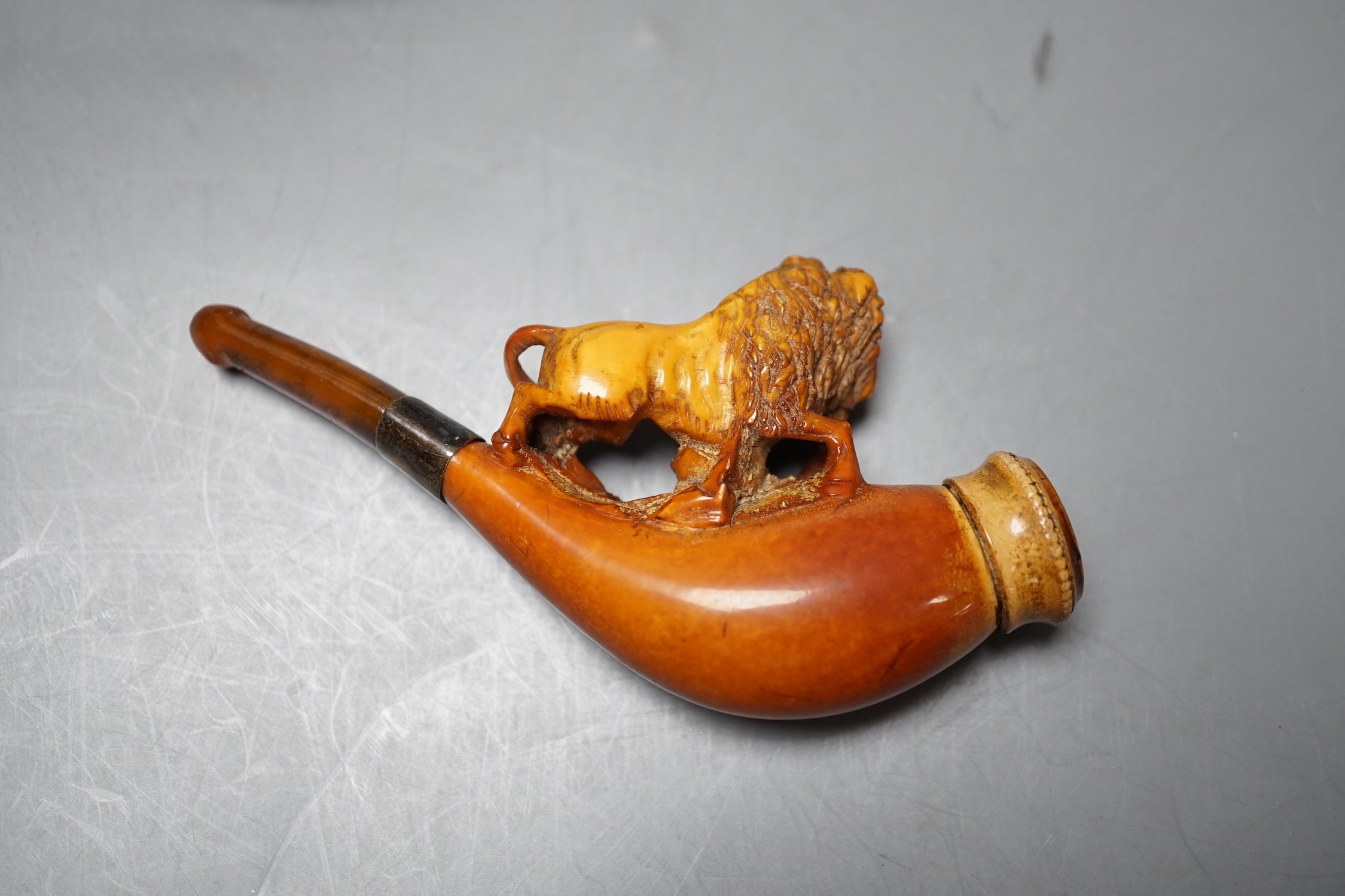 A cased Meerschaum cheroot holder with a carved wooden lion decoration with silver cleaner in fitted case, 12cm overall